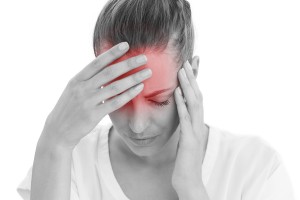 Woman having a headache with her head in her hands on white background